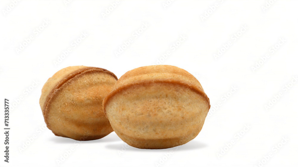 Two fresh and tasty cookies in the shape of a walnut with boiled condensed milk on a white background. A favorite delicacy for children and adults with a delicate filling inside. Two fresh and tasty cookies in the shape of a walnut with boiled condensed milk on a white background. A favorite delicacy for children and adults with a delicate filling inside.