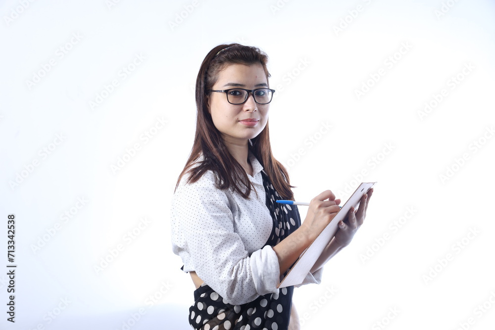 Portrait of a young Happy Indian girl writing on a writing pad. Woman using a chalk and a small white board to write. Portrait of a young Happy Indian girl writing on a writing pad. Woman using a chalk and a small white board to write.