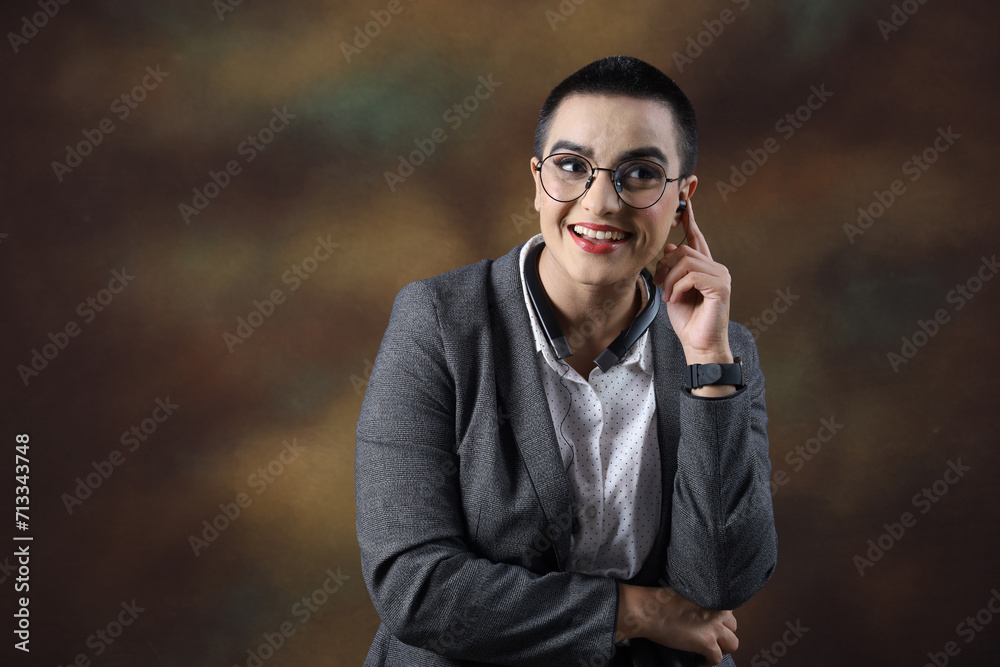 Confident young woman wearing eyeglasses. Portrait of smiling business woman isolated against grey background, copy space. Proud university student girl with specs. wearing earpads, enjoying music. Confident young woman wearing eyeglasses. Portrait of smiling business woman isolated against grey background, copy space. Proud university student girl with specs. wearing earpads, enjoying music.