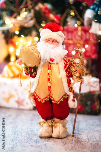 Toy Santa Claus on a background of Christmas lights. New Year