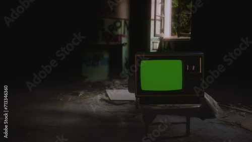 Abandoned TV Green Screen Old Derelict House Vintage Television Tracking Shot. Vintage television with green screen on a derelict abandoned house. Tracking shot photo