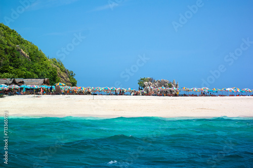 Colorful umbrellas on the clean and beautiful beach of Koh Khai Island  Krabi  Thailand. Sunny blue sky.