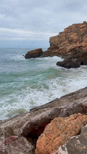 Portugal's coastline, waves crashing against a rocky shoreline