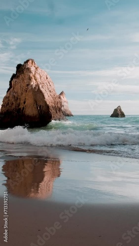 Portugal's coastline, the serene ocean waves gently embrace the rocky formations slow motion