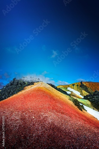 Iconic colorful rainbow volcanic mount Brennisteinsalda in Landmannalaugar mountains in Iceland. Summer, dramatic scenery with blue sky and smoky lava field.