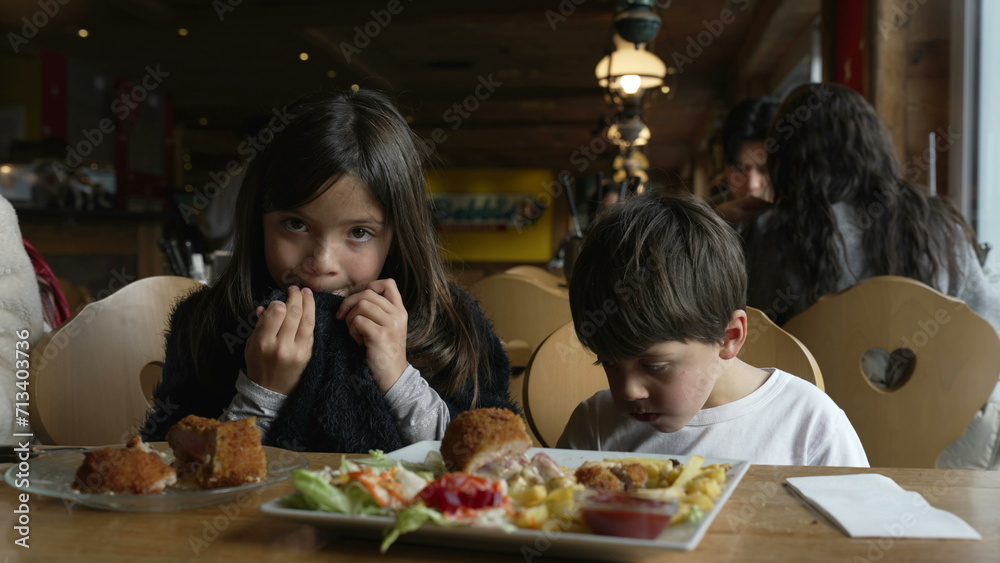 Kids eating food at diner, children enjoying cozy restaurant, siblings little brother and sister
