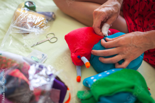Serene Mid Adult Caucasian Woman Sewing and Creating Textile Toys at Home as Holidays Presents fro Children- Hands Close Up