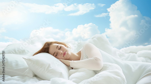 Beautiful young woman with a smile sleeps on a bed with a soft white dazzling blanket and pillows that float in the clouds against the background of a blue bright sky