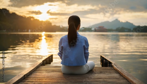 photoshoot of Peaceful lifestyle shot of woman sitting on dock from back at sunset on Lake.ai generated