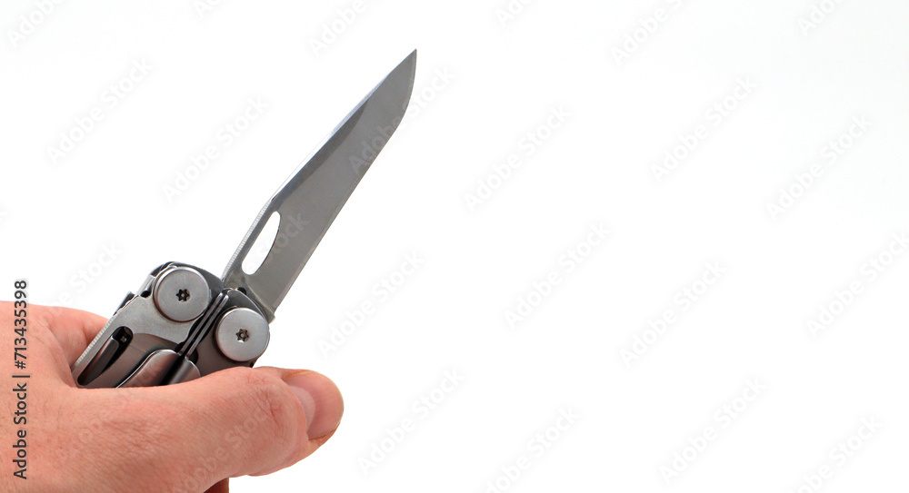 On a white background, a man's hand holds a steel multi-tool with an open knife blade. Pocket folding knife. Portable multi-tasking multi-tool with many tools. EDC concept. Tool for daily practice. On a white background, a man's hand holds a steel multi-tool with an open knife blade. Pocket folding knife. Portable multi-tasking multi-tool with many tools. EDC concept. Tool for daily practice.
