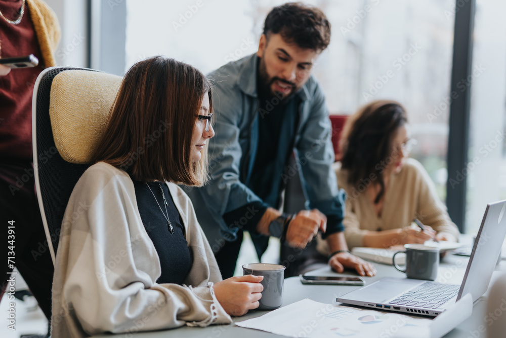 Multicultural employees collaborating on project development for company's profit growth in a creative office environment.