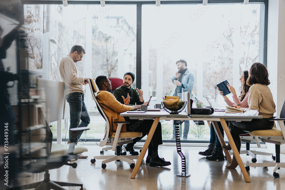 Diverse employees collaborating in an innovative office. Discussing marketing strategies, analyzing finances, and solving problems together. Representing teamwork and cooperation.