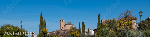 Panoramic view of the upper Albaicin (Granada, Spain) with the church of San Cristóbal between cypresses on a sunny winter morning