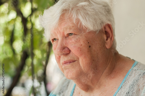 Senior grey haired woman sitting on bench outdoors