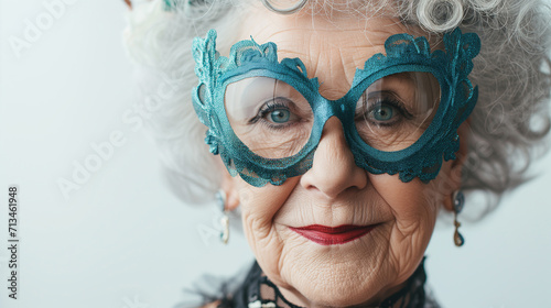 Senior hispanic grey- haired woman wearing venetian carnival mask pointing thumb up to the side on grey background