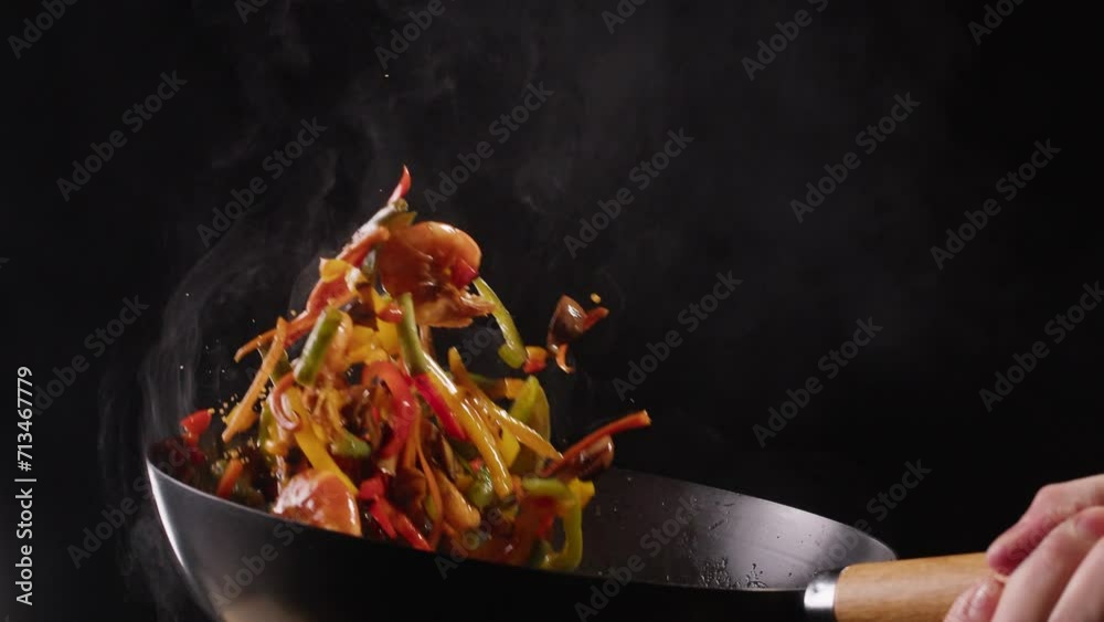 Chef cooking shrimps with mix vegetables on wok frying pan close-up. Prawns on fire throwing them on pan. Restaurant Food concept. Sea food.