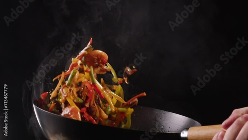 Chef cooking shrimps with mix vegetables on wok frying pan close-up. Prawns on fire throwing them on pan. Restaurant Food concept. Sea food.