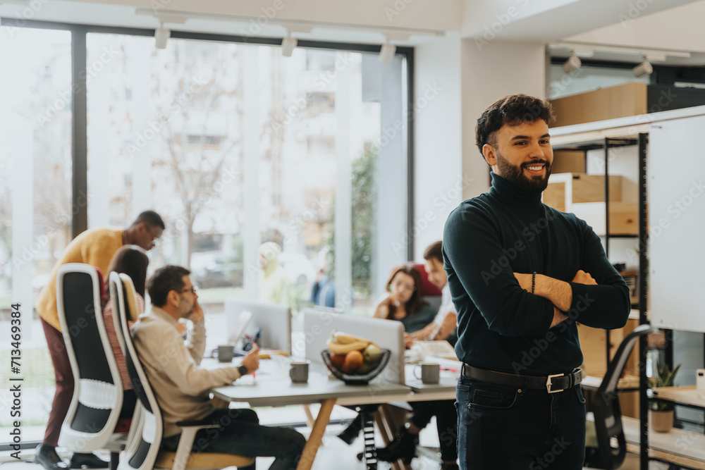 © qunica.com - Man posing at the office. Copy space. A team of coworkers discussing marketing strategies in a office. They are collaborating and sharing ideas to find solutions for business growth and profitability.