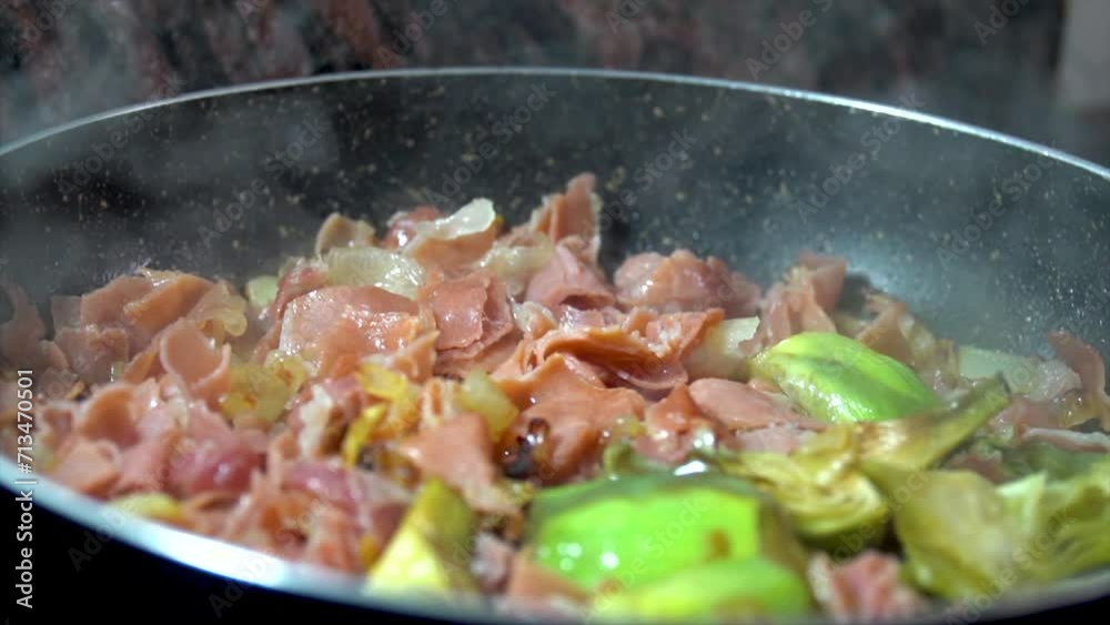 Cooking on a pan artichokes with ham, domestic life, Mediterranean diet.