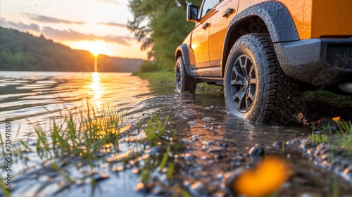 Orange suv by a lake at sunset, off-road adventure concept photo