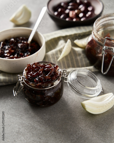 Two jars or preserves with Delicious French Appetizer Freshly Cooked Onion Confit. Concrete loft background. 