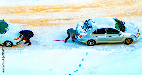 Drivers attach a tow rope to their cars to tow a faulty frozen automobile in the frosty winter.Technical assistance, defective car towing.Towing equipment. Tugging
