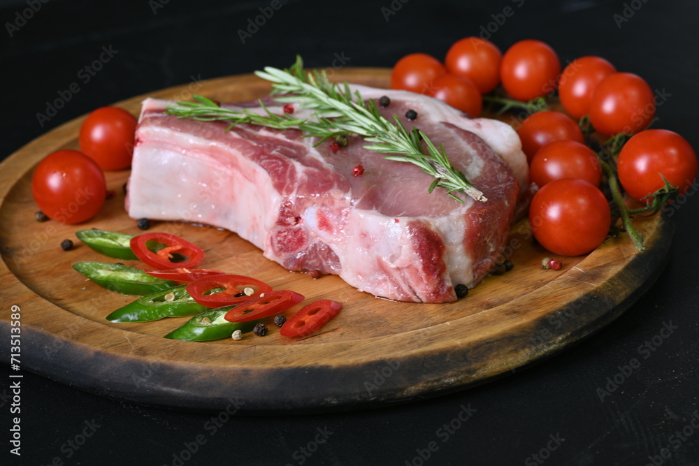 Overhead fresh meat. Pork chops with rosemary and spices on a wooden board Overhead fresh meat. Pork chops with rosemary and spices on a wooden board