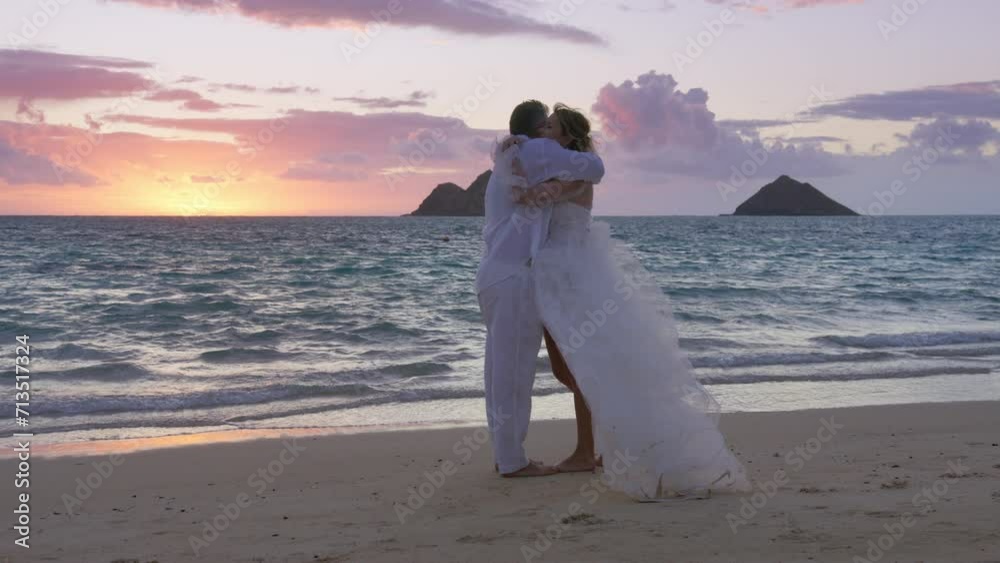 Happy newlywed husband and wife hugging each other on tropical beach at summer sunset. Romantic couple dressed in boho style wedding outfit enjoy romantic lifestyle outdoor together. Love concept 4K Happy newlywed husband and wife hugging each other on tropical beach at summer sunset. Romantic couple dressed in boho style wedding outfit enjoy romantic lifestyle outdoor together. Love concept 4K