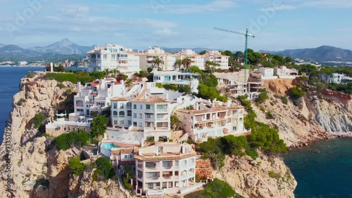 Drone footage of residential holiday apartments nested on rocky cliffs of Santa Ponsa, Calvia on Mallorca island. Expensive and luxury real estate in mediterranean. photo