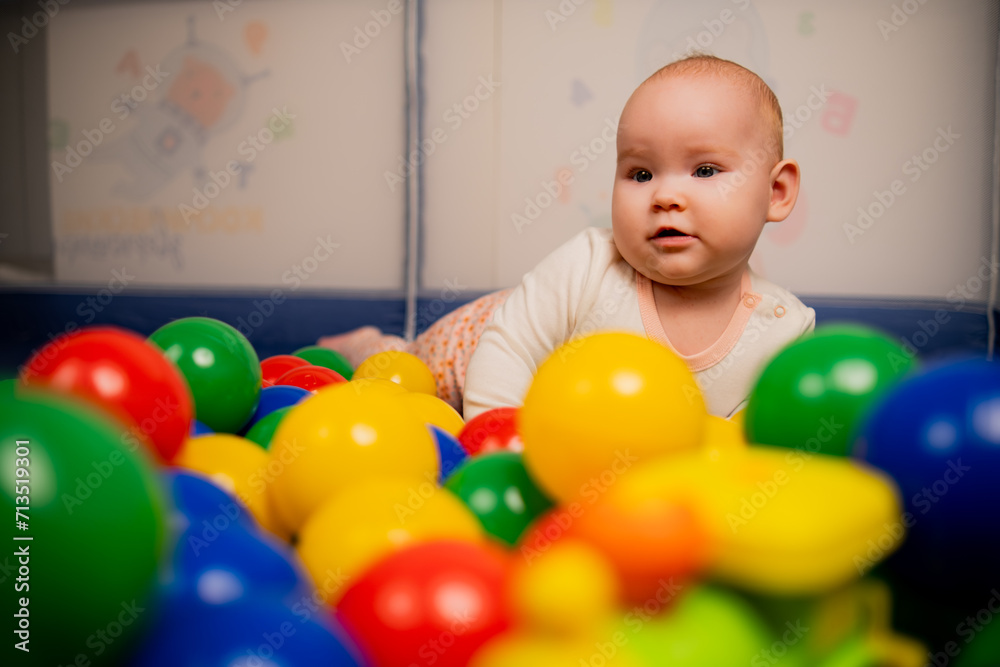 Cute baby girl playing with colorful balls in kindergarten. Cute baby girl playing with colorful balls in kindergarten.