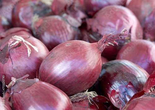 close up on fresh red onions piled up for sale at farmers market. Fresh organic vegetables.