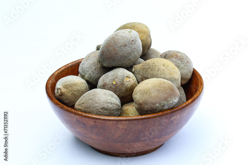 Terminalia bellirica in a wooden bowl on white background side view  photo