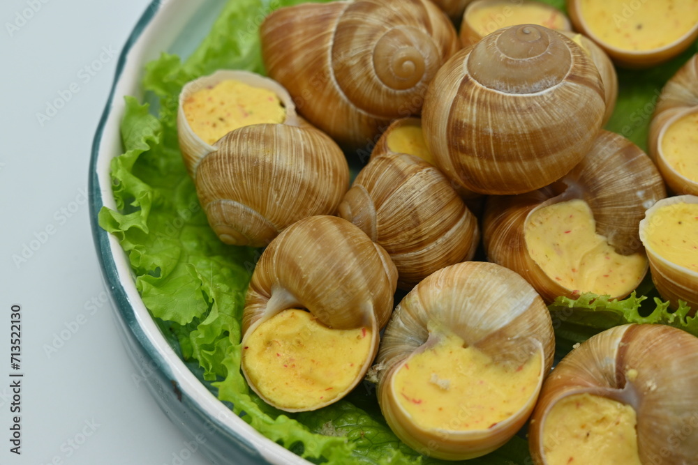 Delicatessen food - Bourgogne Escargot Snails with garlic butter in a pan., white background. Top view Delicatessen food - Bourgogne Escargot Snails with garlic butter in a pan., white background. Top view