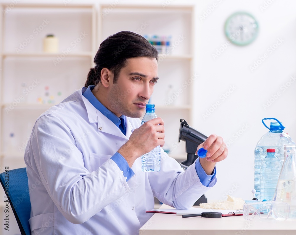 Young male chemist experimenting in lab Young male chemist experimenting in lab