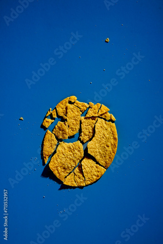 Golden and crusty potato chips on blue background. Minimalistic food photo. 