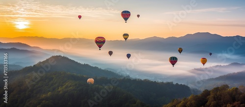 Colorful hot air balloons fly over the mountain fog