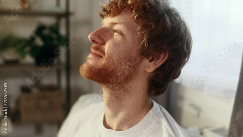 Close up portrait of smiling carefree red haired young man feeling absolutely happy and satisfied enjoying great day at home Self confidence guy looking ahead feel proud alone