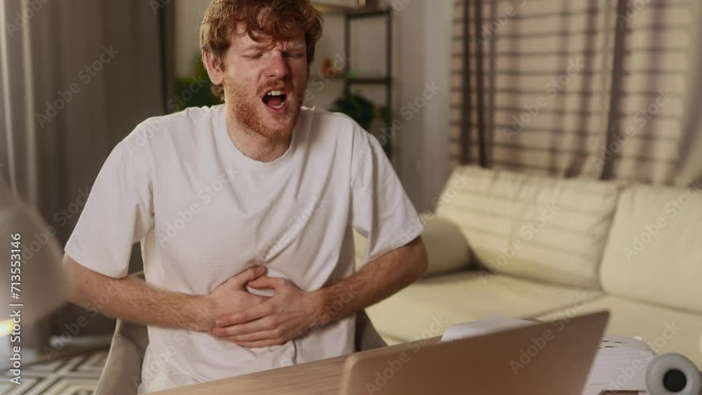 Sick unhealthy young man student or freelancer clasping belly and suffering from severe abdominal pain spasm irritable bowel syndrome of diet at home workplace Sick unhealthy young man student or freelancer clasping belly and suffering from severe abdominal pain spasm irritable bowel syndrome of diet at home workplace