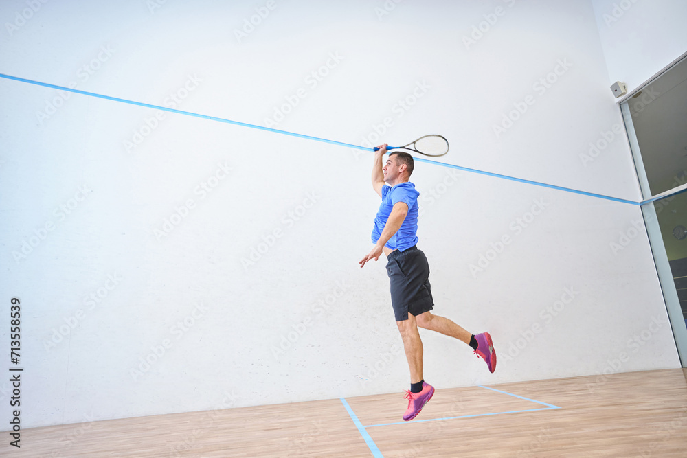 Dedicated jumping man is enjoying squash session