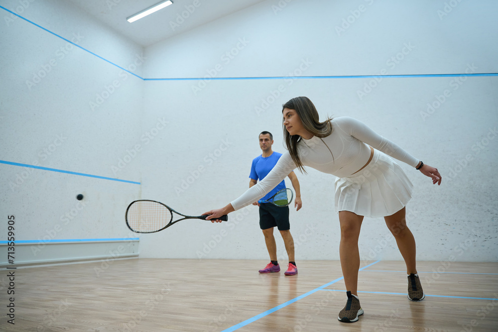 Sporty man and woman playing squash mixing recreation with fitness activity