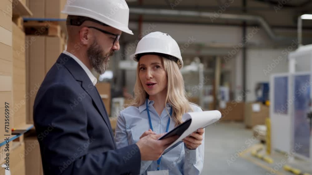 Female warehouse manager talking with logistics employee in warehouse, planning transport of products, goods, talking shipping process. Female warehouse manager talking with logistics employee in warehouse, planning transport of products, goods, talking shipping process.