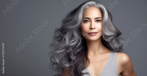 Beautiful woman with long hair on a grey background