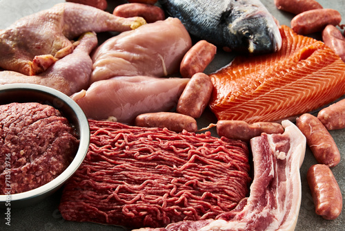 Carnivore diet or low carb diet background concept. Raw animal meat products beef, minced pork and sausages, chicken with dorado fish and salmon. High protein. Close up