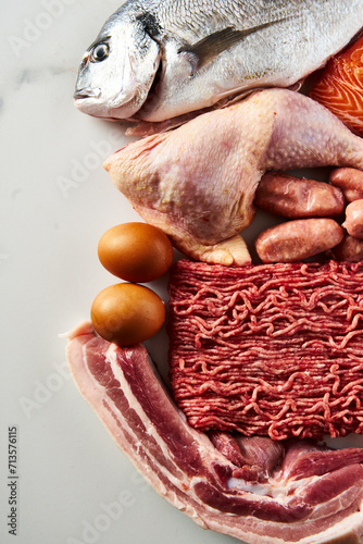 Carnivore diet or low carb diet background concept. Raw animal meat products beef, minced pork and sausages, chicken with dorado fish and salmon. High protein. Top view, copy space