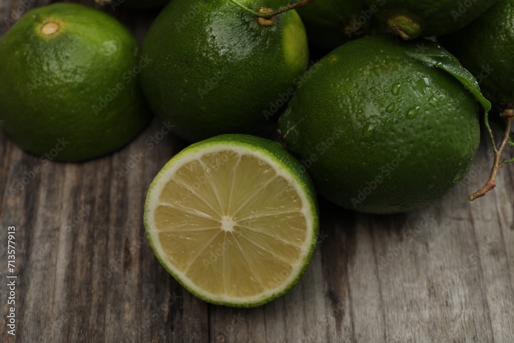 Fresh limes with water drops on wooden table, closeup Fresh limes with water drops on wooden table, closeup