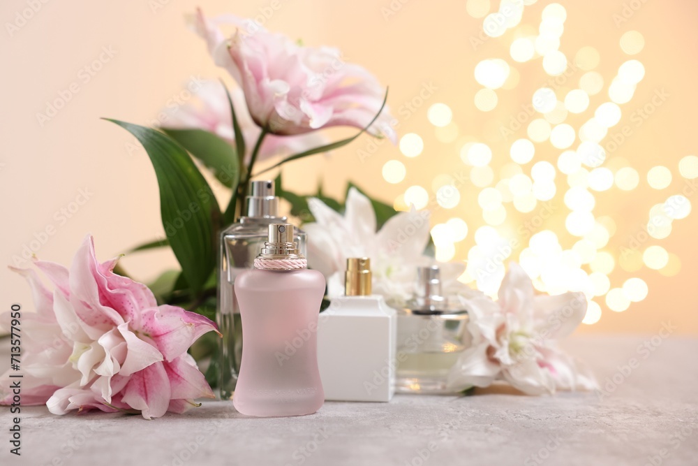 Bouquet of beautiful lily flowers and perfume bottles on table against beige background with blurred lights, closeup Bouquet of beautiful lily flowers and perfume bottles on table against beige background with blurred lights, closeup