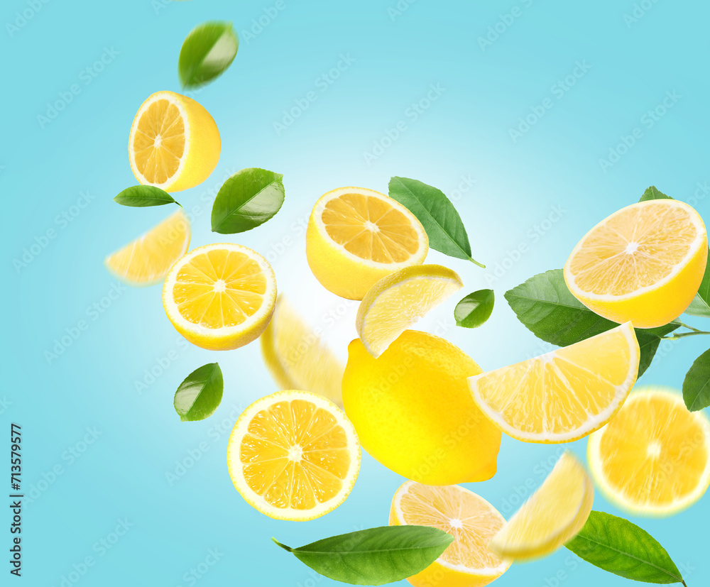 Fresh lemons and green leaves flying on light blue background