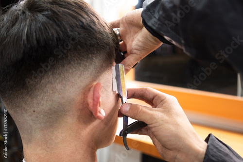 a man cutting a client's sideburns
