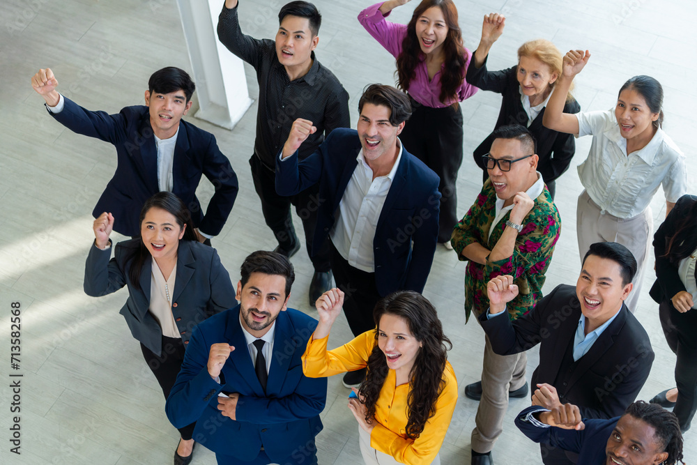 Happy diverse business people celebrating their success project.Top view. Group of successful energetic employees cheer up gratefully while looking at sky with white background. Intellectual.