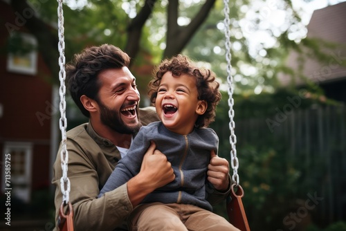 Father's Day. Diverse black dad with his son on a swing in backyard garden, smiling and looking happy, spending quality time together.  photo